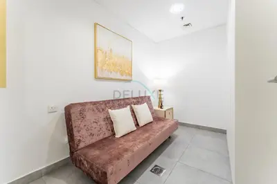 a couch in a room with a painting on the wall at Near Circle Mall And Parks, Easy Access to Al Khail Road And Close to RTA Bus Stop, Lucky Residences, JVC by Deluxe Holiday Homes in Dubai