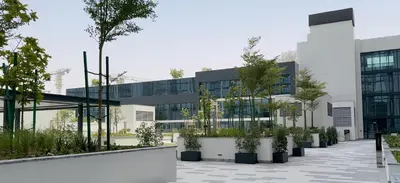 an office building with potted plants in front of it at Modern 1BHK Bunk Beds and Sofa Bed By Czechin in Dubai