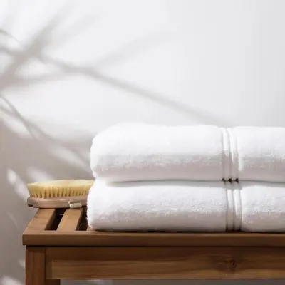 a stack of white towels on a wooden table at Private Pool Paradise Villa! Dubai Mall in a Flash! Complimentary Full Mid-Stay Refresh for 1 week stay in Dubai