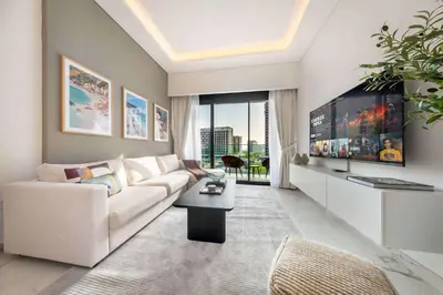 a living room with a white couch and a tv at AirDXB - Meydan Apartment sleeps 4 in Great Location in Dubai