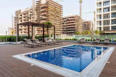 a swimming pool with chairs and a gazebo on a building at AirDXB - Meydan Apartment sleeps 4 in Great Location in Dubai