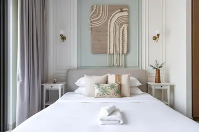 a bedroom with a large white bed with two tables at GuestReady - Creek View l 2Bed l Lagoon Escape in Dubai