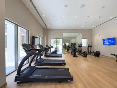 a gym with a row of treadmills at GuestReady - Creek View l 2Bed l Lagoon Escape in Dubai