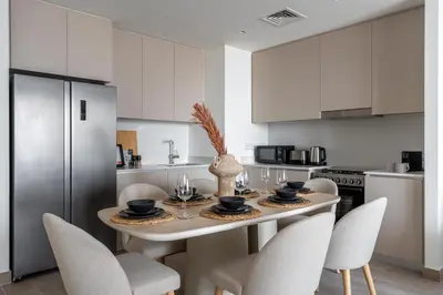 a kitchen with a table and chairs in a kitchen at GuestReady - Creek View l 2Bed l Lagoon Escape in Dubai