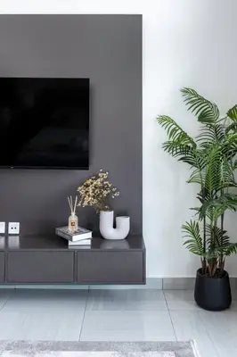 a living room with a tv and two potted plants at GuestReady - Stylish l High Floor Studio in Dubai