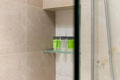 a shower with a glass shelf in a bathroom at Waves - Luxury Beachfront Escape - Skyline & Sea Views in Dubai