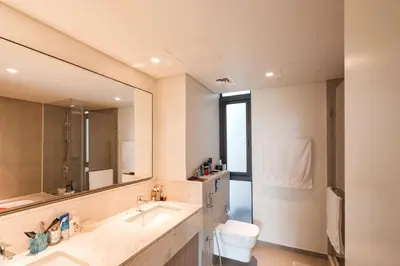 a bathroom with a sink and a toilet and a mirror at Private room in a luxury villa at Dubai hills in Dubai