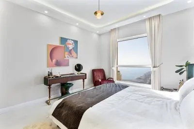 a bedroom with a bed and a desk and a window at Luxury 2-Bedroom with Sea & Ain Dubai View in Dubai