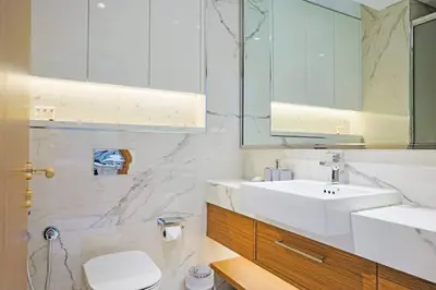 a bathroom with a sink and a toilet and a mirror at Spacious Luxury Escape - Modern Comfort in Riviera in Dubai