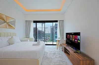 a bedroom with a bed and a flat screen tv at Spacious Luxury Escape - Modern Comfort in Riviera in Dubai