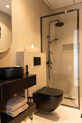 a bathroom with a black toilet and a shower at Apartment Studio Blue Wave in Dubai