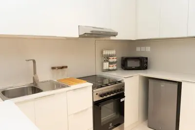a kitchen with a sink and a stove and a microwave at Apartment Studio Blue Wave in Dubai