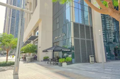 a building with an umbrella and tables and chairs at The Boulevard Central Suite Near Burj Khalifa in Dubai