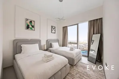 a hotel room with two beds and a window at Grande 2BR Balcony Burj & Fountain Views by Evoke in Dubai