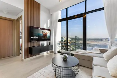 a living room with a couch and a tv at Charming 1-Bedroom Close to Downtown in Dubai