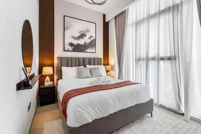 a bedroom with a large bed and a large window at Charming 1-Bedroom Close to Downtown in Dubai