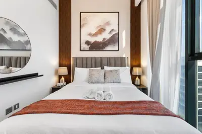 a bedroom with a large white bed with two towels on it at Charming 1-Bedroom Close to Downtown in Dubai