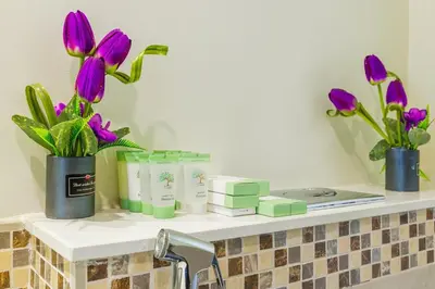 a bathroom counter with purple flowers and candles on it at High floor, Canal View, Parking, Crib, Dubai Mall & Burj Khalifa in Dubai