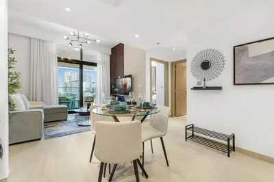 a dining room and living room with a table and chairs at 1 Bedroom Royal Dubai Stay in Dubai