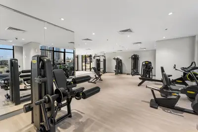 a gym with a lot of treadmills and ellipticals at 1 Bedroom Royal Dubai Stay in Dubai