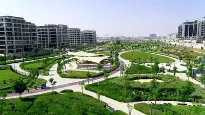 a park with trees and buildings in a city at Dubai Hills Retreat Garden, Pool & Park Access in Dubai