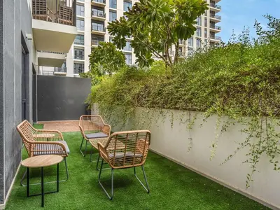 a group of chairs and a table on a patio at Dubai Hills Retreat Garden, Pool & Park Access in Dubai