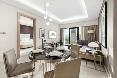 a dining room with a table and chairs and a couch at BLVD - Damac Paramount with Burj Khalifa View in Dubai