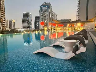 a swimming pool with a toilet in a city at Vogue Downtown Mag 318 near Burj Khalifa and Dubai Mall, Studio Apartment with Balcony, Canal and City Skyline View, Access to all Amenities in Dubai