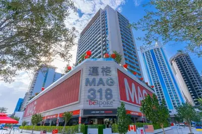 a building with a sign on it in a city at Vogue Downtown Mag 318 near Burj Khalifa and Dubai Mall, Studio Apartment with Balcony, Canal and City Skyline View, Access to all Amenities in Dubai