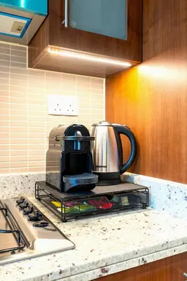 a tea kettle on a rack on a kitchen counter at Iconic Address 1BR Above Dubai Mall by Maxx value homes in Dubai