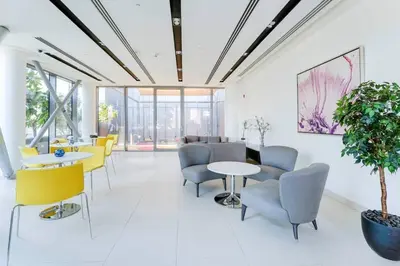 a waiting room with tables and chairs and a plant at Iconic Address 1BR Above Dubai Mall by Maxx value homes in Dubai