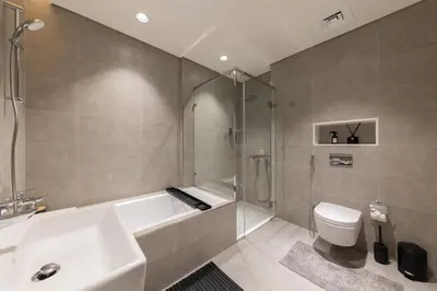 a bathroom with a tub and a toilet and a sink at Designer 3BR Lagoon Views Gym District One in Dubai