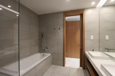 a bathroom with a tub and two sinks and a shower at Beachfront 2BR with Maids Room One JBR Sea Palm Ain Atlantis Views in Dubai