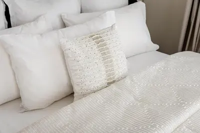 a white bed with white pillows and a white pillow at Beautiful 2 bed in JBR SHAMS in Dubai