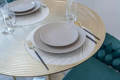 a table with white plates and silverware on it at Chic Studio at ME DO RE Tower Stunning Views in Dubai