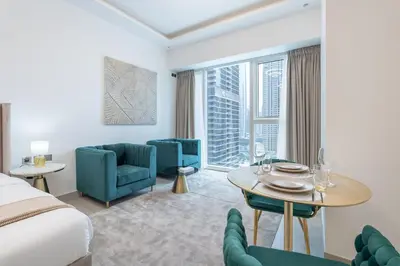 a hotel room with a bed and a table and chairs at Chic Studio at ME DO RE Tower Stunning Views in Dubai