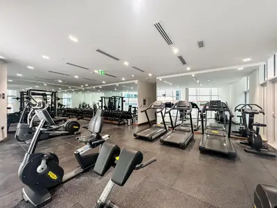 a gym with several treadmills and cardio machines at Stunning Burj Khalifa & Lake View 2BR with GYM and Pool in Dubai