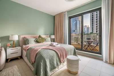 a bedroom with a bed and a large window at Modern Downtown Studio with Balcony & Parking in Dubai