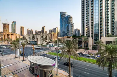 a city with tall buildings and a street with palm trees at Modern Downtown Studio with Balcony & Parking in Dubai