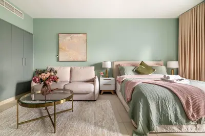 a bedroom with a bed and a couch and a table at Modern Downtown Studio with Balcony & Parking in Dubai