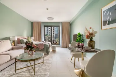 a living room with a couch and a table at Modern Downtown Studio with Balcony & Parking in Dubai