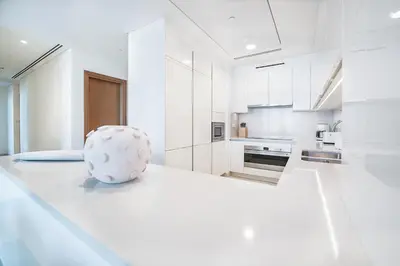 a white kitchen with a vase on the counter at Elegant 2 M with Direct Canal & Iconic View in Dubai