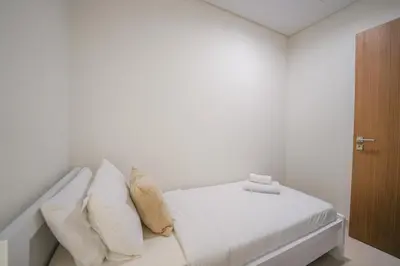 a white bedroom with a bed with white sheets and pillows at Elegant 2 M with Direct Canal & Iconic View in Dubai