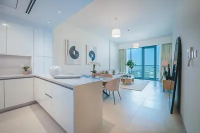 a kitchen and living room with a table and a couch at Elegant 2 M with Direct Canal & Iconic View in Dubai