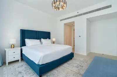 a bedroom with a large bed and a chandelier at Luxury 2BR with Panoramic Sea View Private Beach in Dubai