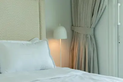 a bedroom with a bed and a lamp next to a window at Luxury 2BR with Panoramic Sea View Private Beach in Dubai