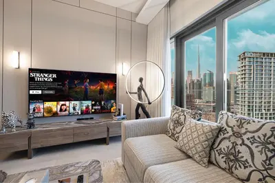 a living room with a couch and a large window at Luxury 1BHK Burj Khalifa & Canal View in Dubai