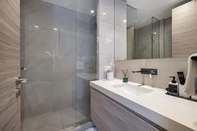a bathroom with a shower and a sink and a mirror at Luxury 1BHK Burj Khalifa & Canal View in Dubai