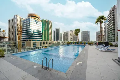 a large swimming pool in a city with tall buildings at Luxury 1BHK Burj Khalifa & Canal View in Dubai