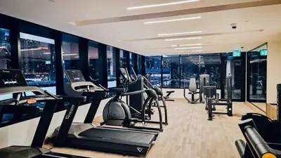 a gym with treadmills and ellipticals in a building at Burj Khalifa View-Beautiful Pool-Gym-Business Bay in Dubai